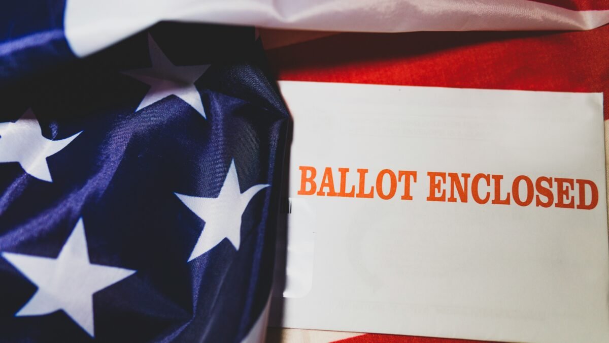 Mail-in ballot with U.S. flag illustrating voting by mail in the 2026 midterm elections